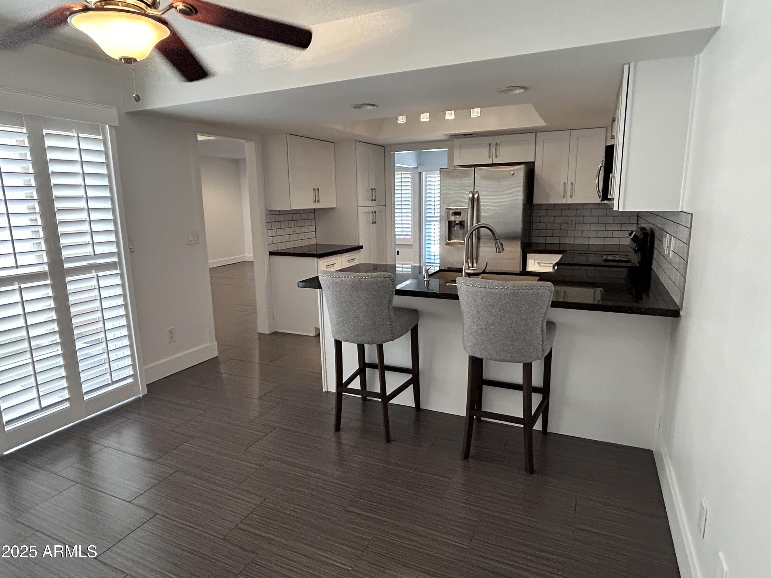 320 East Larkspur Lane Tempe, AZ 85288 - Photo 2 of 16 a kitchen with stainless steel appliances kitchen island granite countertop a stove a sink and a microwave