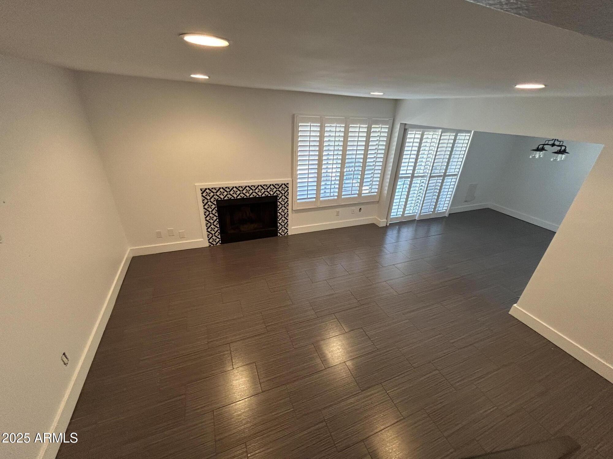 320 East Larkspur Lane Tempe, AZ 85288 - Photo 4 of 16 an empty room with wooden floor and windows