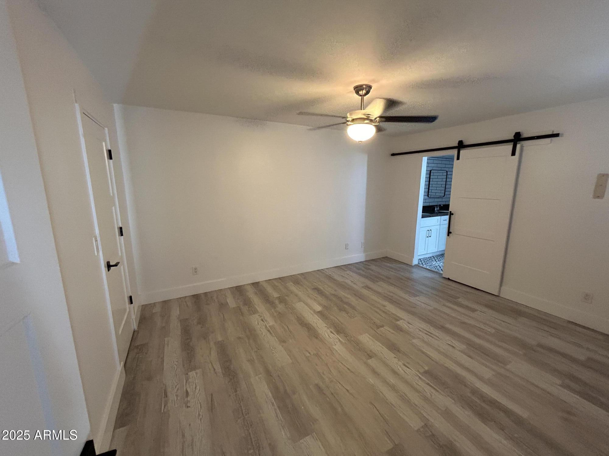 320 East Larkspur Lane Tempe, AZ 85288 - Photo 8 of 16 wooden floor in an empty room with a window