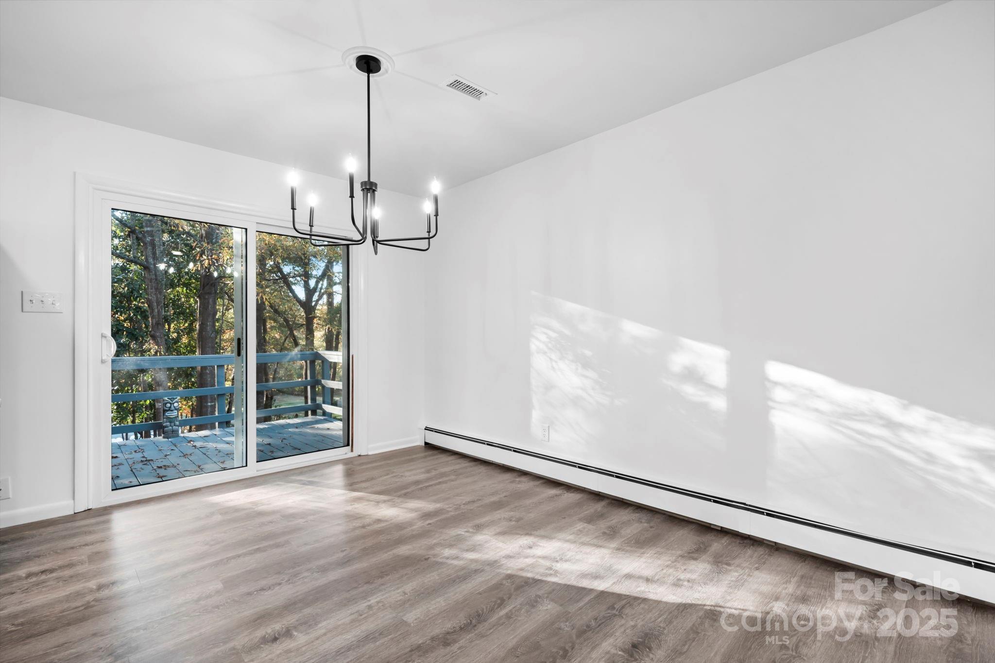 1185 10th St Pl Circle Northwest Hickory, NC 28601 - Photo 11 of 38 a view of a room with wooden floor chandelier and windows