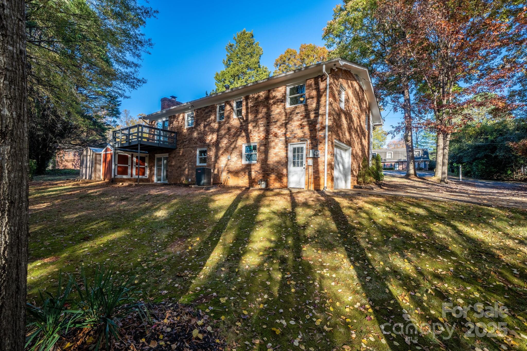 1185 10th St Pl Circle Northwest Hickory, NC 28601 - Photo 35 of 38 a backyard of a building with large trees and plants