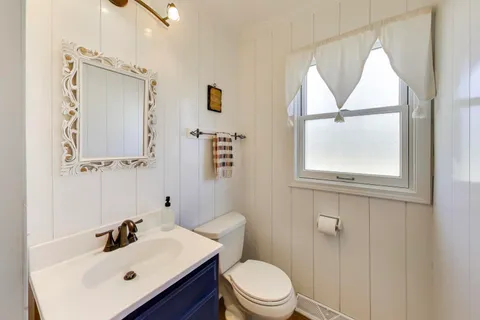 a bathroom with a sink mirror toilet and vanity