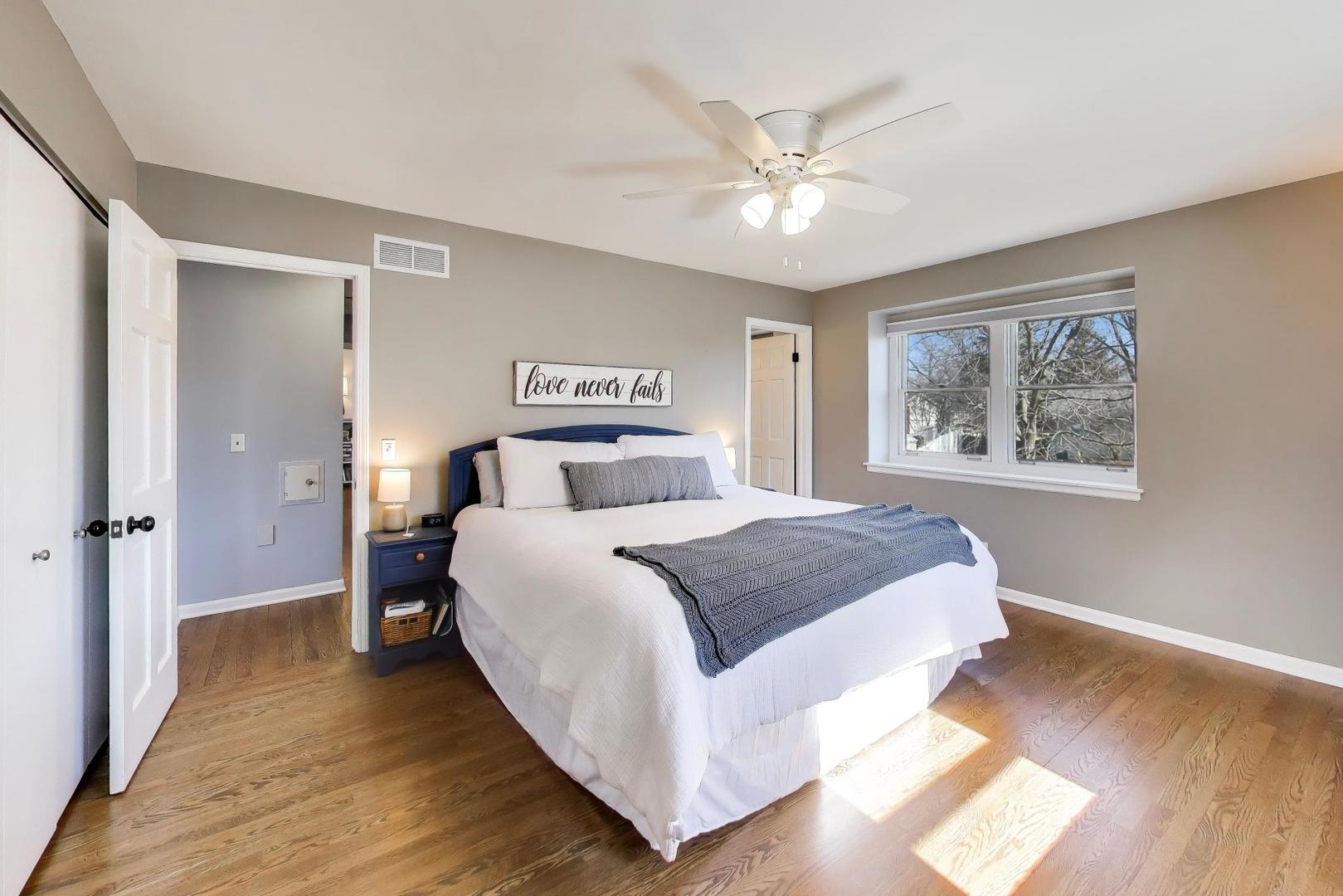 1445 Stoddard Avenue Wheaton, IL 60187 - Photo 16 of 38 a bedroom with a large bed and a chandelier