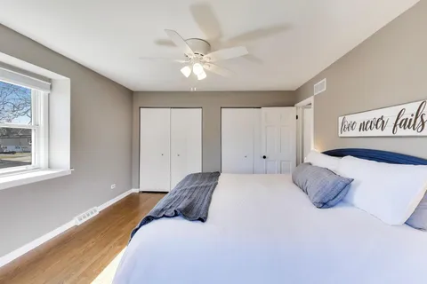 a bedroom with a large bed and a chandelier