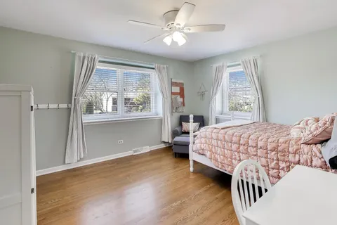 a bedroom with a large bed and wooden floor