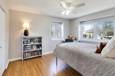 a bedroom with a bed a large window and a chandelier