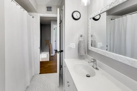 a bathroom with a tub sink and mirror