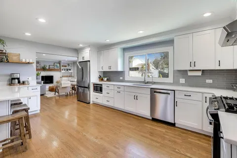 a kitchen with stainless steel appliances granite countertop a stove a sink dishwasher and a refrigerator with cabinets