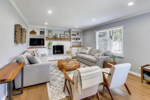 a living room with furniture a fireplace and a flat screen tv