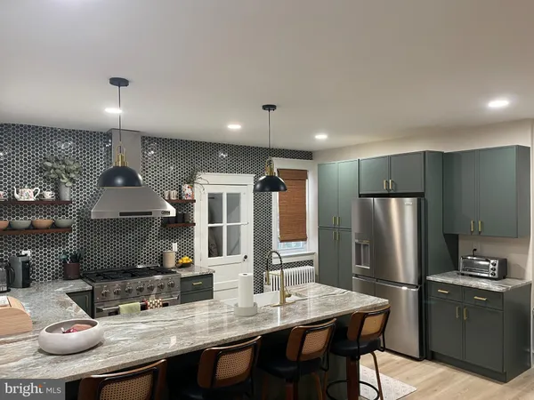 a kitchen with stainless steel appliances granite countertop a sink refrigerator and cabinets