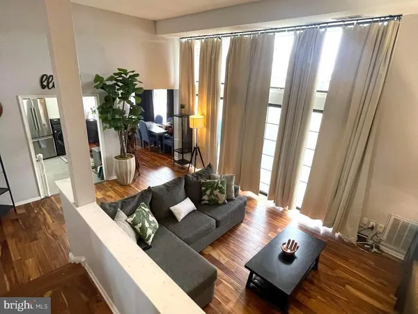 a living room with furniture and floor to ceiling window