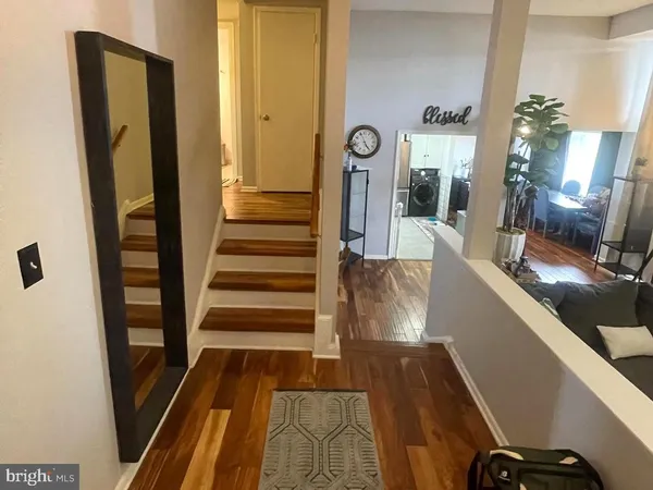 a view of a hallway with wooden floor and staircase