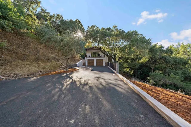 front view of a house with a yard and an trees