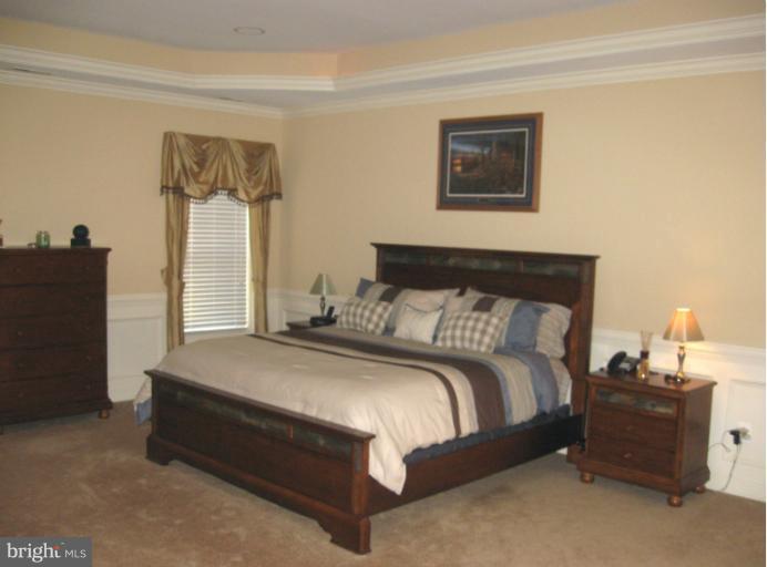 10803 Catron Road Perry Hall, MD 21128 - Photo 8 of 30 a spacious bedroom with a bed and a lamp