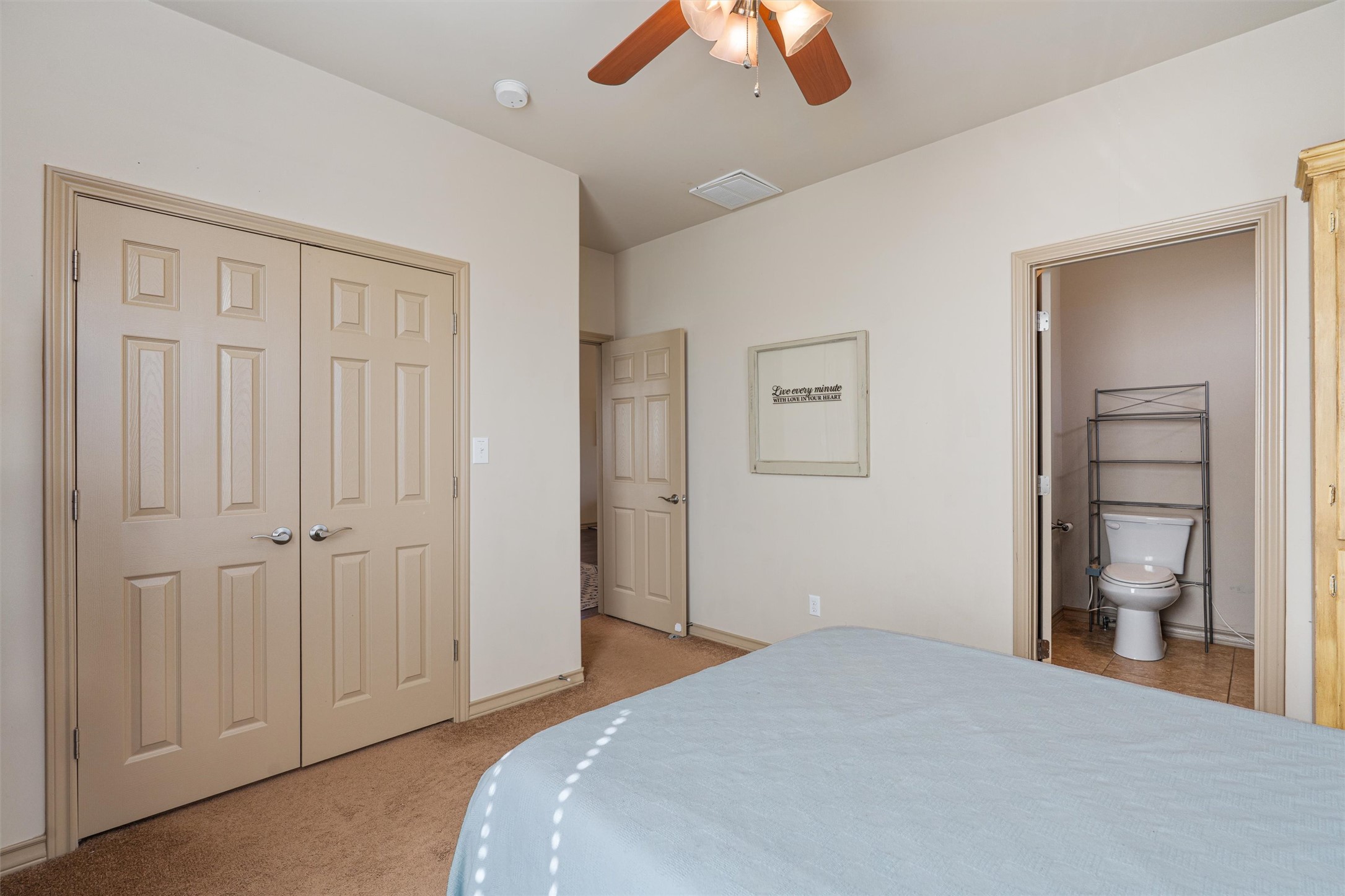 209 Harris Street Elgin, TX 78621 - Photo 13 of 40 Bedroom with light carpet, ceiling fan, a closet, and ensuite bathroom