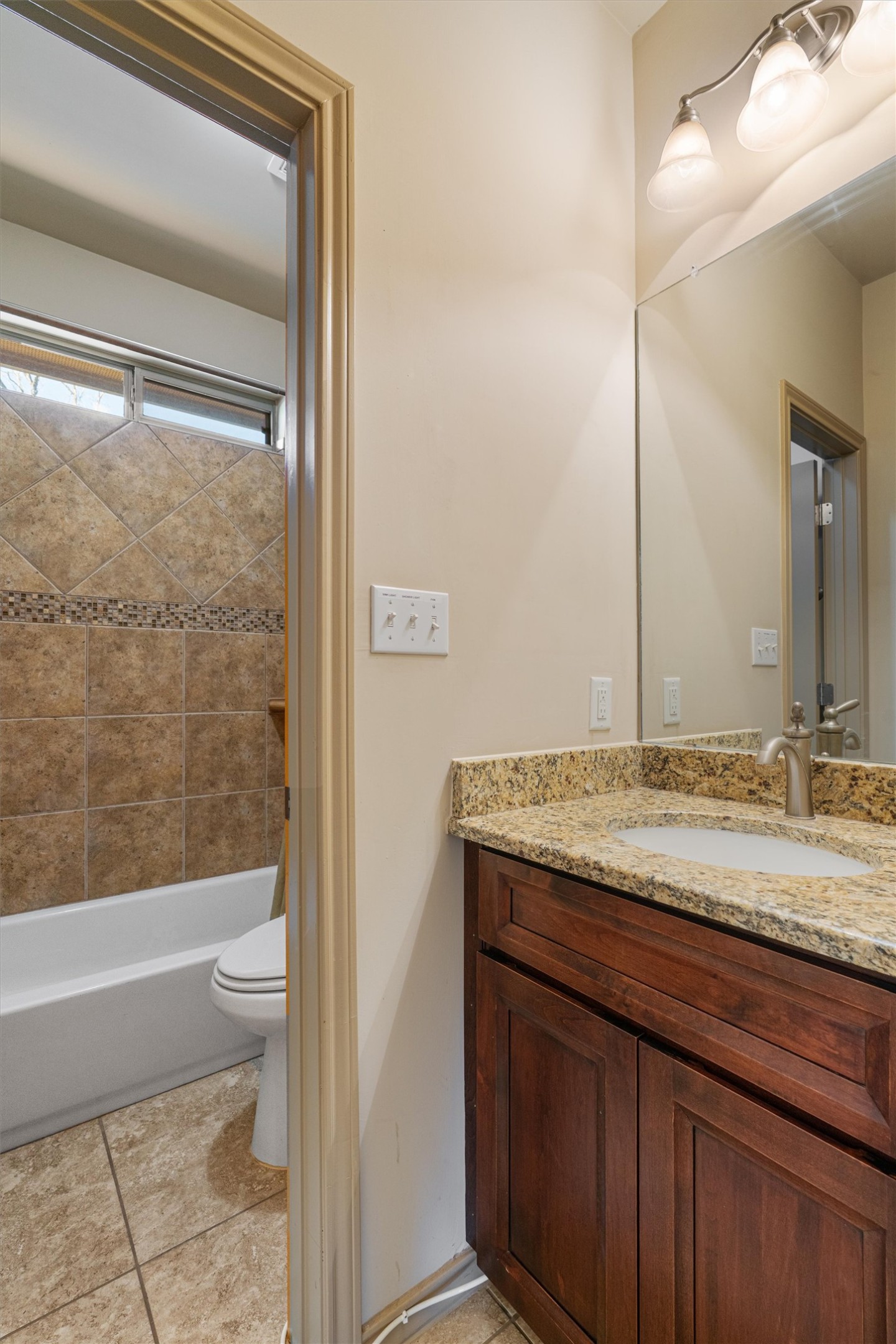 209 Harris Street Elgin, TX 78621 - Photo 18 of 40 Bathroom with vanity, tub / shower combination, and light tile patterned flooring