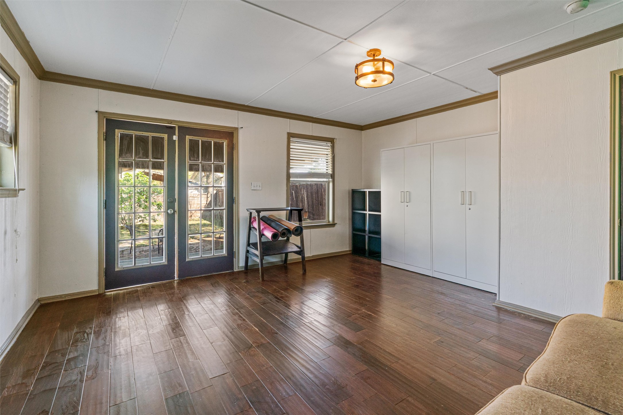 209 Harris Street Elgin, TX 78621 - Photo 29 of 40 Living area featuring french doors, dark wood-style floors, and crown molding