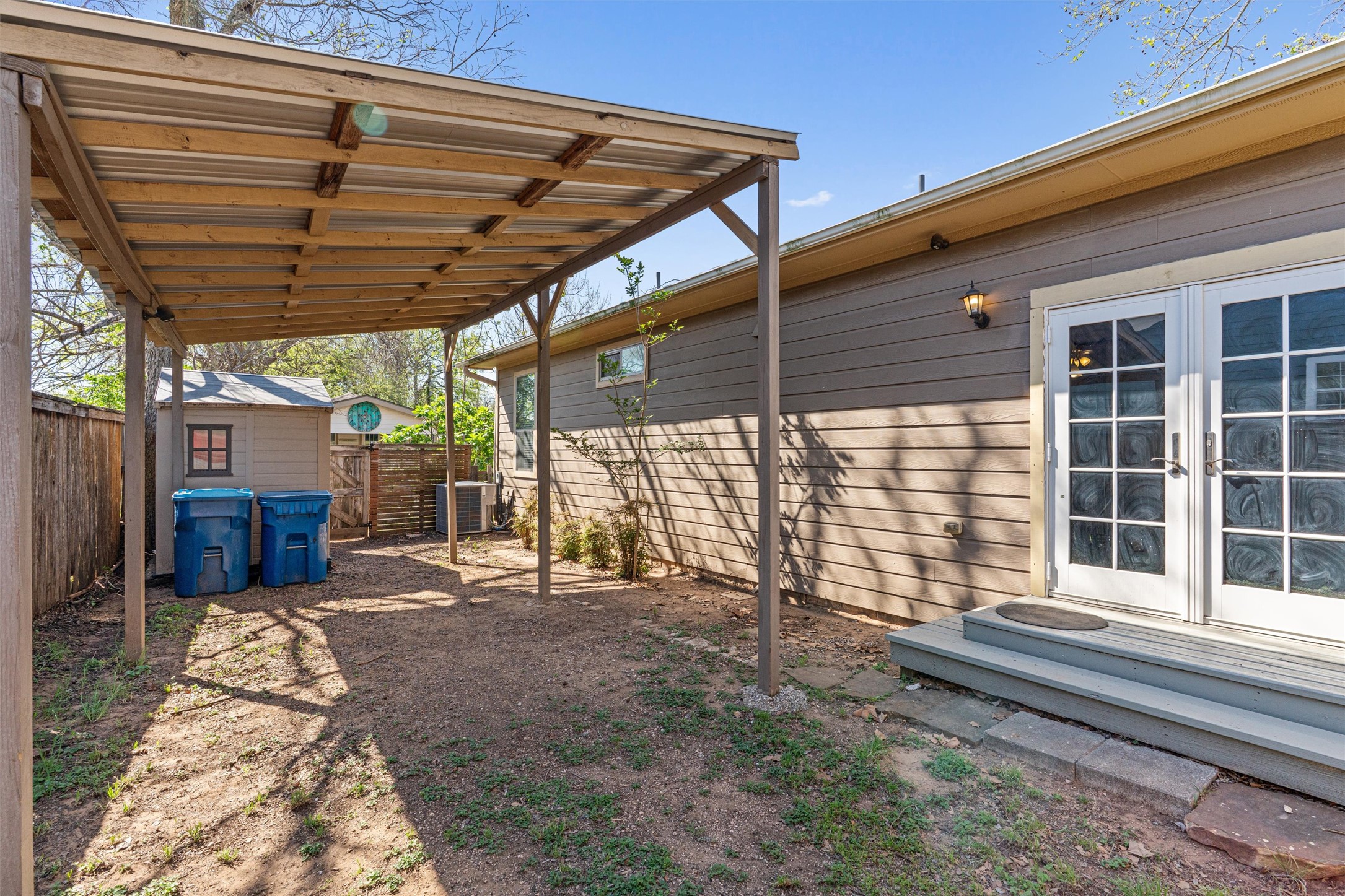 209 Harris Street Elgin, TX 78621 - Photo 40 of 40 Fenced backyard with french doors, a deck, and a storage unit
