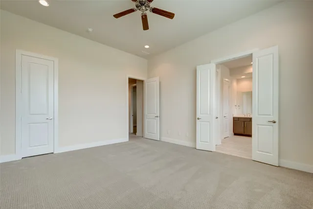an empty room with a ceiling fan and closet area