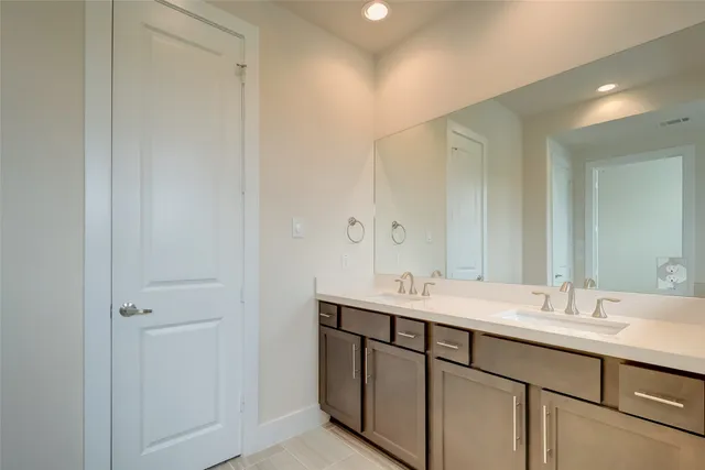 a bathroom with a double vanity sink and a mirror