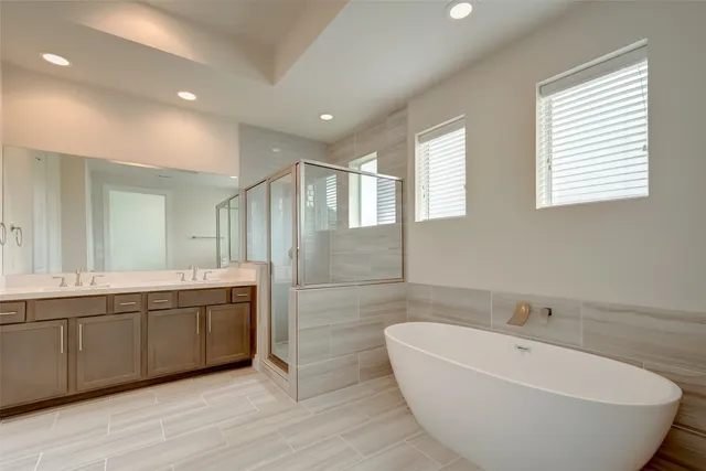 a spacious bathroom with a tub sink and mirror