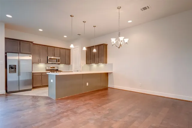 a large kitchen with kitchen island a sink stainless steel appliances and cabinets