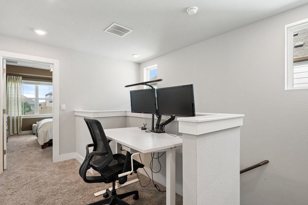 7403 Travertine Spring Drive, Unit 117 Austin, TX 78744 - Photo 19 of 37 A versatile loft space with recessed lighting and neutral carpet, perfect for a home office.