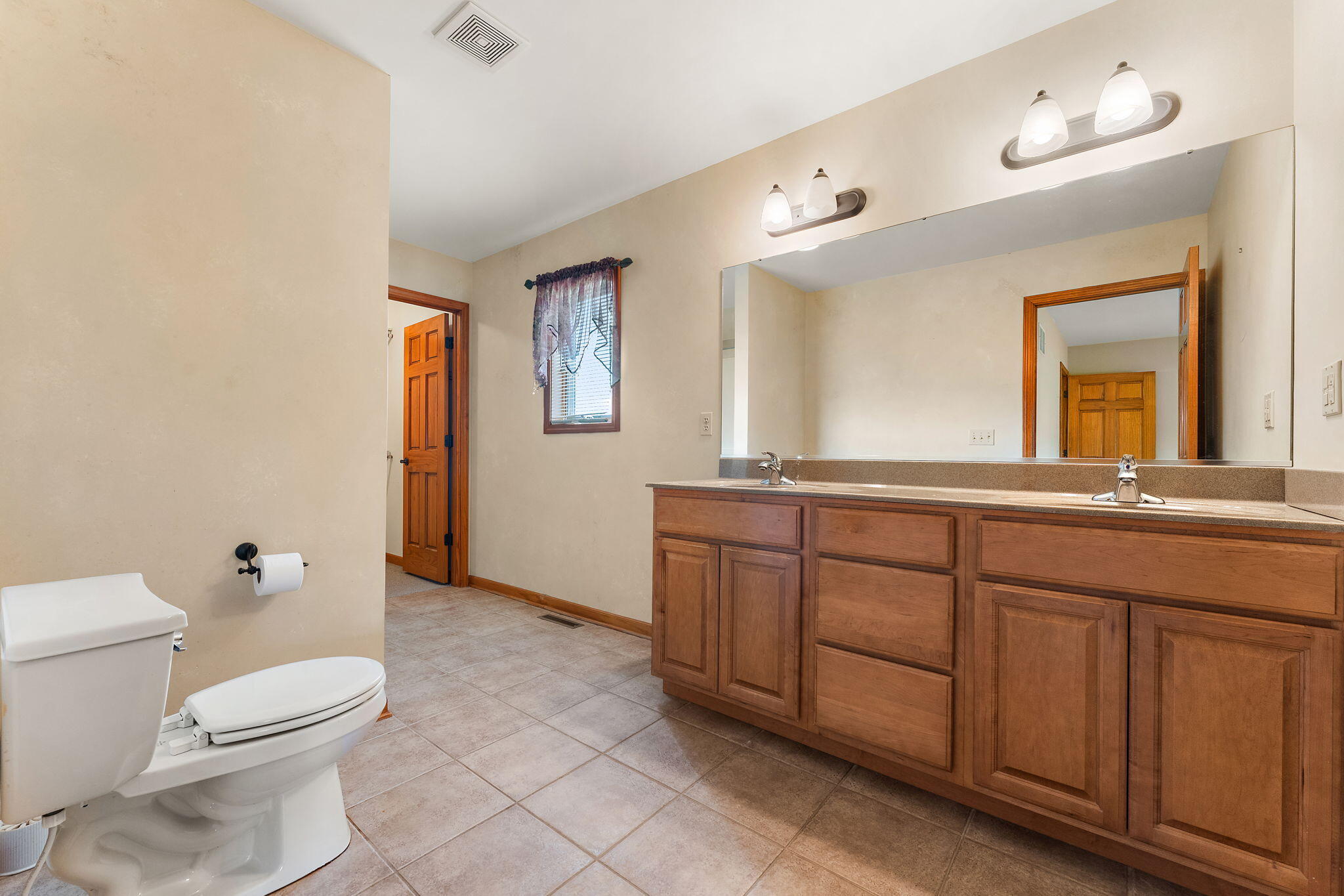 5005 West 152nd Court Crown Point, IN 46307 - Photo 9 of 22 a spacious bathroom with a toilet a sink and a mirror