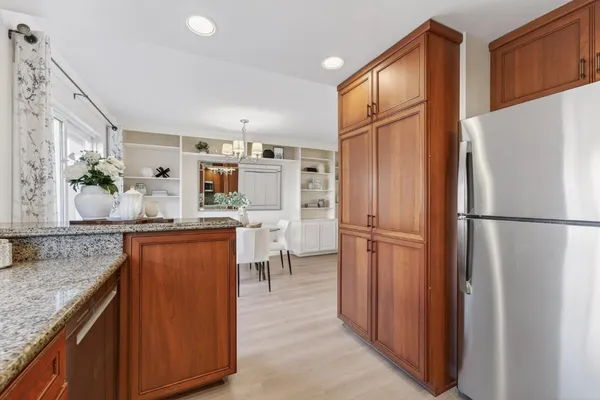 a kitchen with stainless steel appliances granite countertop a refrigerator and a stove top oven