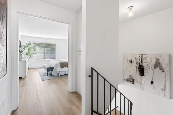 a view of a bedroom with a bed and wooden floor