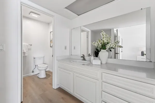 a bathroom with a granite countertop sink mirror and toilet