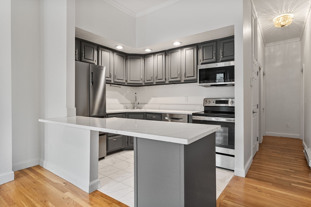 431 Columbus Avenue, Unit 4 Boston, MA 02116 - Photo 12 of 27 a kitchen with stainless steel appliances a refrigerator and a stove top oven
