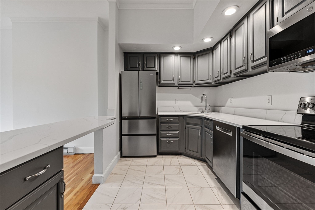 431 Columbus Avenue, Unit 4 Boston, MA 02116 - Photo 9 of 27 a kitchen with stainless steel appliances granite countertop a refrigerator stove top oven and sink