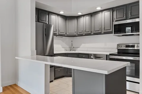 a kitchen with stainless steel appliances granite countertop a refrigerator and a stove top oven