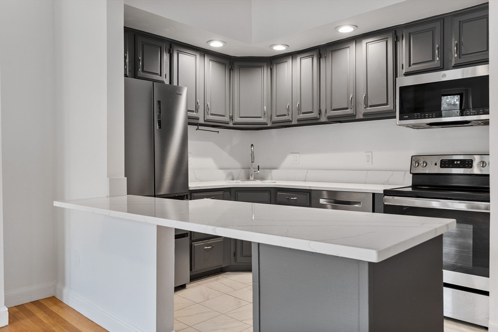 431 Columbus Avenue, Unit 4 Boston, MA 02116 - Photo 10 of 27 a kitchen with stainless steel appliances granite countertop a refrigerator and a stove top oven