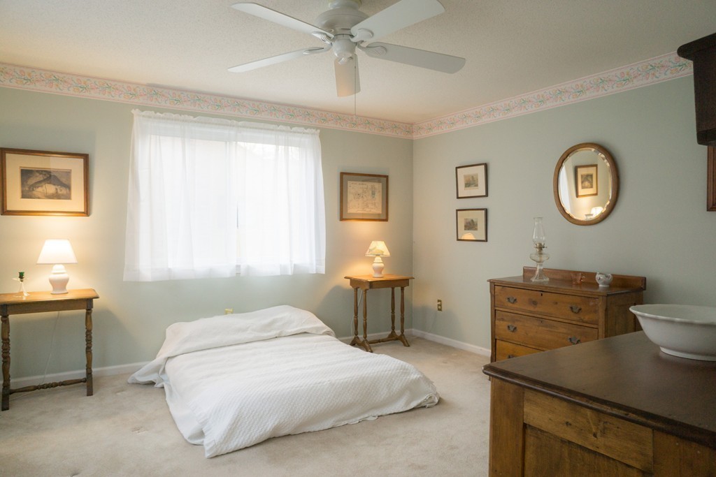 82 Meeting House Path, Unit 82 Ashland, MA 01721 - Photo 16 of 23 a bedroom with a bed and a chandelier