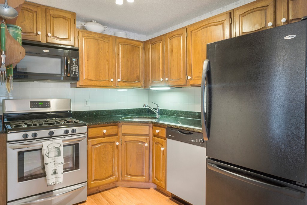 82 Meeting House Path, Unit 82 Ashland, MA 01721 - Photo 3 of 23 a kitchen with granite countertop cabinets stainless steel appliances and a sink