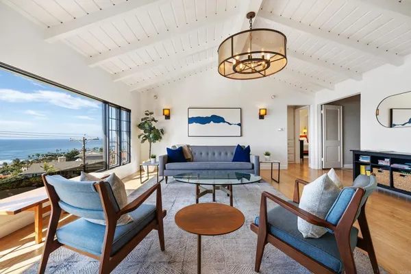 a living room with furniture a rug and a floor to ceiling window