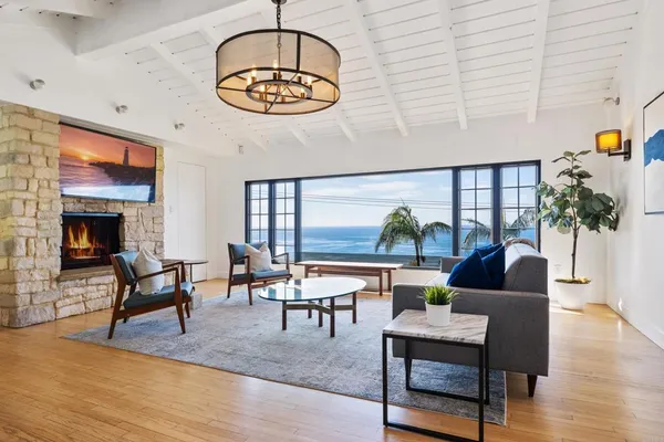 a living room with furniture a chandelier and a fireplace