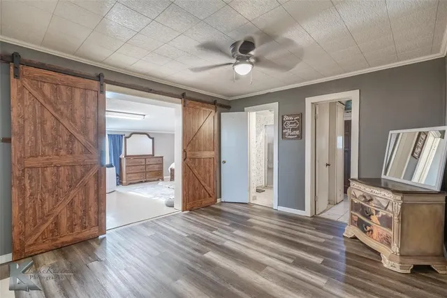 a view of a livingroom with wooden floor and a ceiling fan