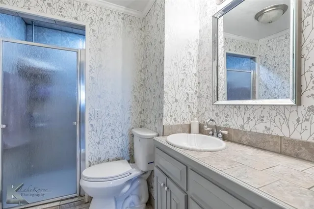 a bathroom with a granite countertop sink toilet and shower