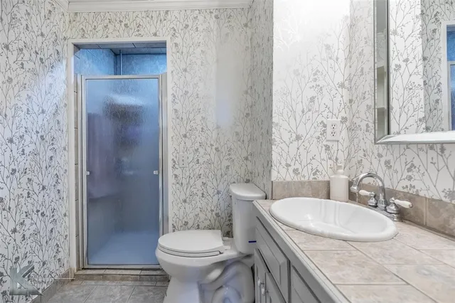 a bathroom with a granite countertop sink toilet and shower