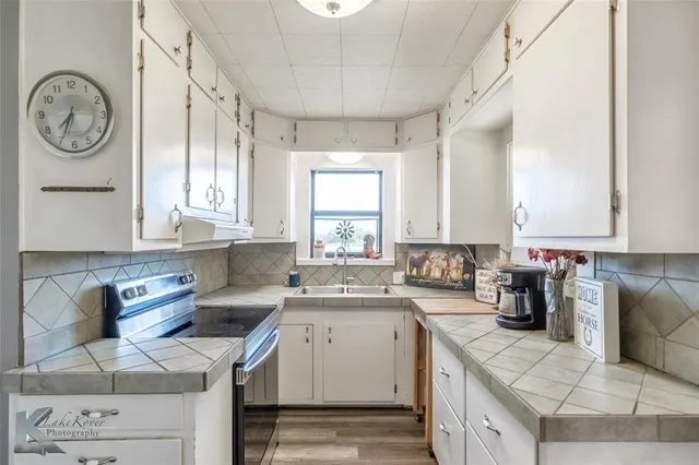 a kitchen with a stove a sink a refrigerator and a window