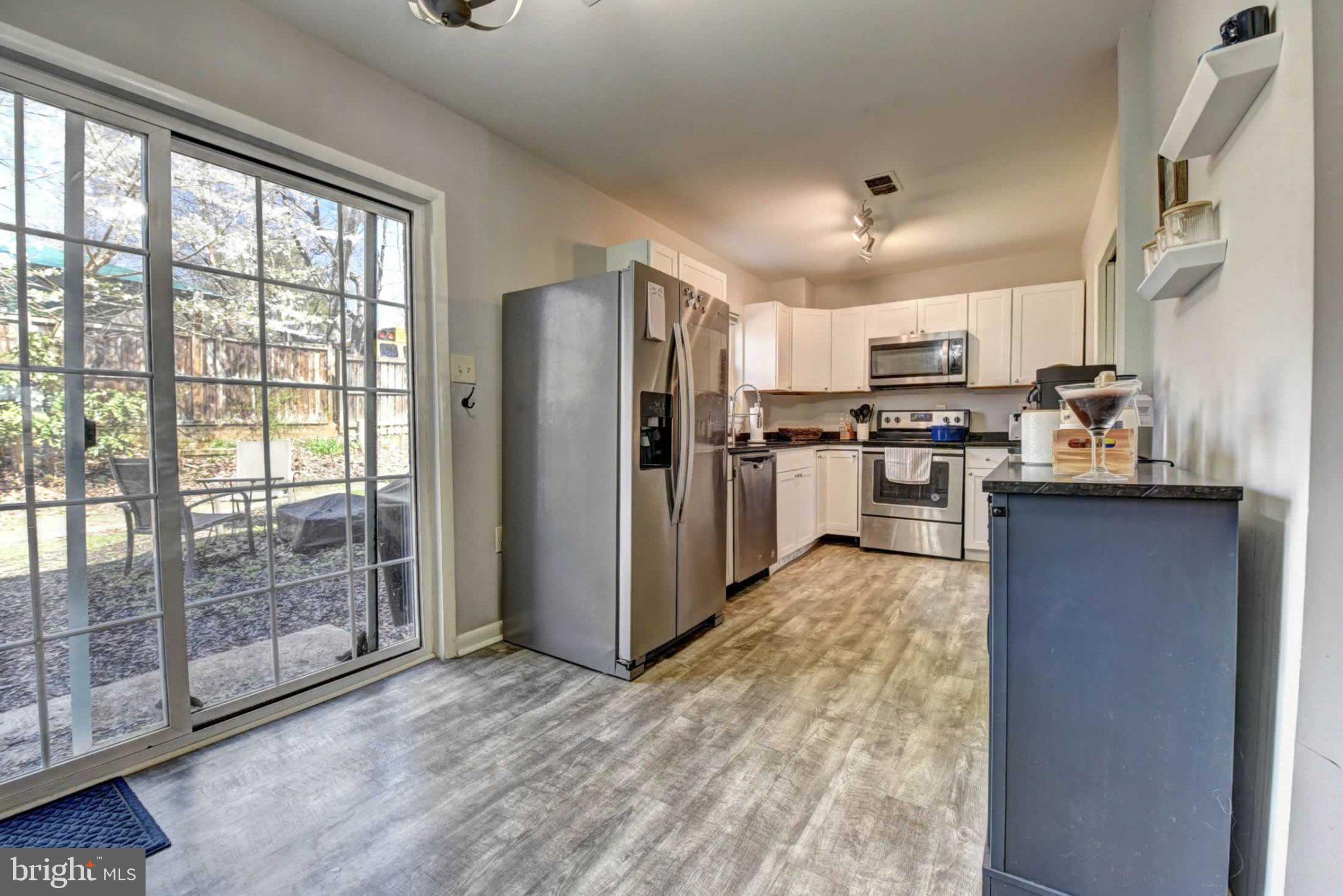 2226 Gunsmith Square Reston, VA 20191 - Photo 11 of 35 a kitchen with kitchen island granite countertop a refrigerator stove top oven and sink