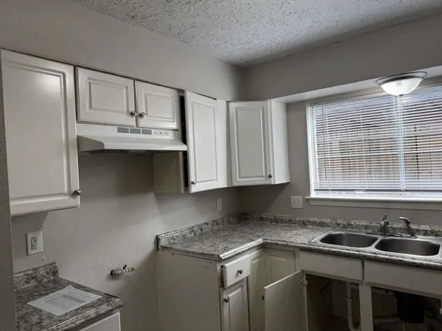 a kitchen with stainless steel appliances granite countertop a sink stove and cabinets