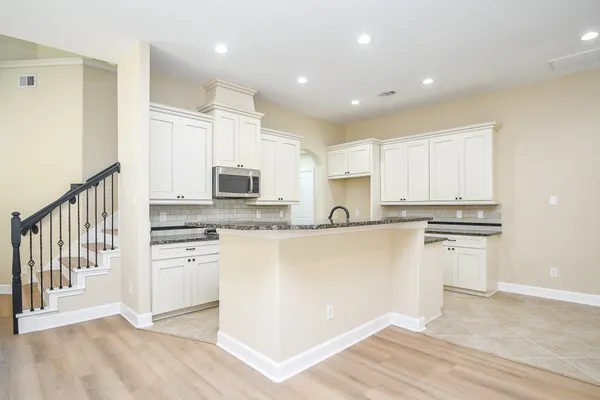 a stove top oven sitting inside of a kitchen