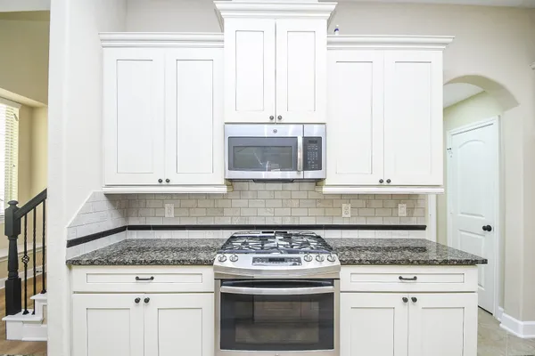 a view of kitchen with granite countertop cabinets and sink