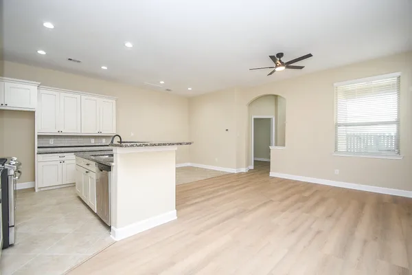 a view of a kitchen with a sink and dishwasher a refrigerator with wooden floor