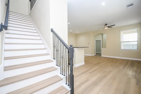 a view of a hallway with wooden floor and staircase