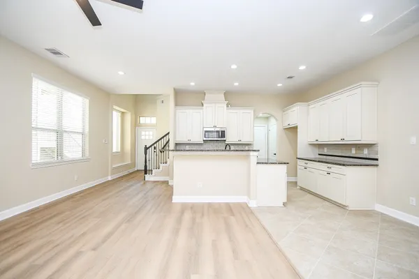 a kitchen with a refrigerator and white cabinets